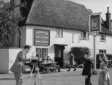 Kind Hearts and Coronets_Mazzini takes a photo outside the pub